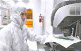 Video: Picture of a researcher at a microscope in a clean room suit