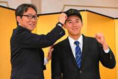 阪神・東辰弥編成ディレクター(左)に帽子を被せてもらう創価大・立石正広