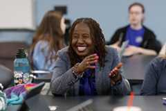 Faculty smiling and talking with students