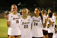 Addison Peters (16), Kaylie Smith (22) and Sydney Bassa (24) pose with the "States Up" hand sign following a match against Southern Miss. TXST won 6-1.