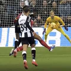 A soccer player in a black and white striped jersey takes a shot at goal as the opposing goalkeeper prepares to block, with other players nearby.
