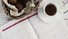 A calendar next to a cup of tea.