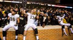 Commodore players celebrate with fans after defeating Tennessee.