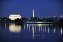 a view overlooking the water with a tour boat and the monuments in the background