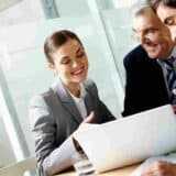 3 professionals in a meeting discussing a report of some sort
