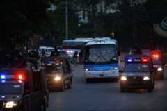 Security personnel escort buses carrying the Zimbabwe and Pakistan cricket teams as they leave a practice session at the Gaddafi Cricket Stadium in Lahore on May 19, 2015. — AFP