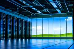 A large server farm with windows looking out over green fields and blue sky