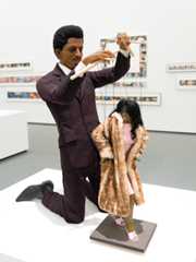 Sculpture of a man pulling puppet strings on a female figure