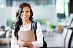 Asian student holding her books and smiling