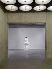 Koons statue holding a blue ball taken from behind the entrance.