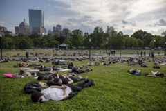 Protesters lie on Boston Common as if handcuffed during a protest on Wednesday. (Robin Lubbock/WBUR)
