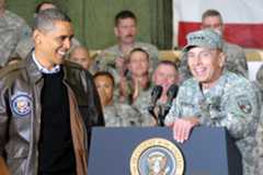 President and Commander in Chief Barack Obama smiles approvingly as Gen. David H. Petraeus, commander of U.S. and international forces in Afghanistan, introduces him to a crowd of some 3,500 service members and civilian in a hangar at Bagram Air Base. The president made a surprise visit to the base, where he visited wounded troops in the base hospital and pinned five with Purple Hearts before meeting with Petraeus and U.S. Ambassador to Afghanistan Karl Eikenberry. Obama thanked service members for their dedication and sacrifices, noting that important progress is being made. (Photo by U.S. Army Staff Sgt. Lorie Jewell) (Released)