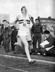 Roger Bannister breaks the tape at 3 minutes 59.4 seconds, a new world's record. (Central Press Photo)