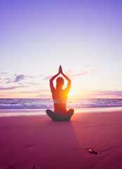 woman practicing yoga on beach