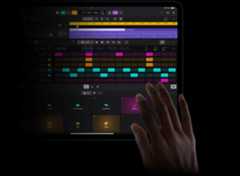 Hand touching an iPad Pro screen to create sound beats in Logic Pro for iPad on iPad Pro