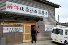 事務所の入り口には「解体は最後の最後‼」と書かれた看板が掲げられている=2025年10月18日、石川県輪島市、石川幸夫撮影