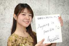 「Anything is Possible!」とメッセージが書かれた色紙を持つバイオリニストの廣津留すみれさん=2025年12月4日、東京都渋谷区、上田幸一撮影