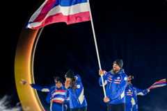 6日、山岳部プレダッツォでの開会式で、チャンロウン兄妹はタイの旗手を務めた。大きな国旗を掲げるマルク（右）と、カレン（右から2人目）=AP