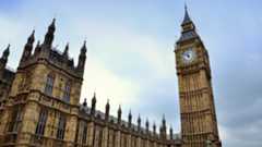A view of the London Parliament building, showing Big Ben and a blue sky