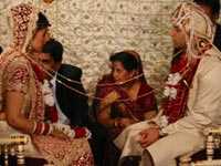 Bride and groom with string tied around both of them as they face each other