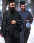 Greek Orthodox priests wearing beards, black robes and flat-topped hats