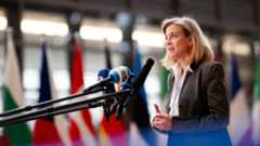Foreign Minister Meinl-Reisinger in Brussels: EU engagement in Ukraine and the Middle East in Focus, Picture: BMEIA/Gruber Foreign Minister Beate Meinl-Reisinger stands in front of several microphones. She speaks and gestures with both hands. Several national flags can be seen blurred in the background.