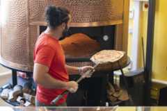 A pizza going in the oven