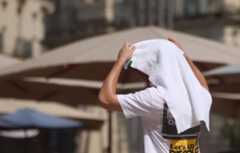 A person covers themselves with a towel as temperatures reach 38C in Montpellier, France on 19 July 2023.