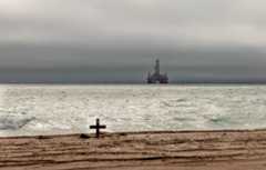 An oil rig looms amid threatening skies over the Atlantic Ocean off the coast of Namibia.