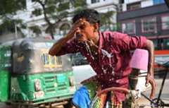 A rickshaw driver washing his face with water during a hot day in Dhaka, Bangladesh, on 15 April 2024.
