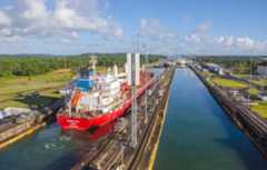 Red cargo ship transits through Gatun Locks, Panama Canal.