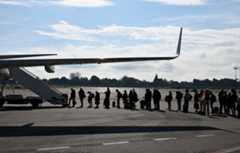 People waiting to get on a plane on the runway. Credit: SJBright / Alamy Stock Photo. Image ID: 2YRJ7J5.