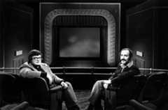 MET-AJ-3-KOGAN-EBERT-0405.JPG Film critics Roger Ebert, left, and Gene Siskel pose on the set of their TV show, relaunched as "Sneak Previews," in 1976. The set used forced perspective to create the illusion that they were watching film clips from a theater’s balcony. (WTTW)