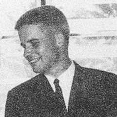 A faded black and white photograph of Michael M. Deuel looking to the side.