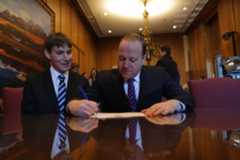 Governor Polis with First Gentleman Reis Signing a Document