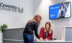 Two staff members talking at a help desk