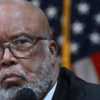 Rep Benny Thompson in a dark suit speaks into a microphone at a House committee hearing with an American flag in the background