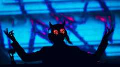 Rezz on stage with her hands up wearing her glasses
