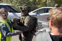 This still image taken from a video shows a federal law enforcement officer pushing demonstrators out of the way of a vehicle outside a U.S. Immigration and Customs Enforcement field office in Durango. (Video still courtesy of Compañeros: Four Corners Immigrant Resource Center via Facebook)