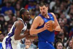 Denver Nuggets center Nikola Jokić, right, looks to drive to the net as Sacramento Kings center Precious Achiuwa, left, defends in the first half of an NBA basketball game Saturday, Nov. 22, 2025, in Denver. (AP Photo/David Zalubowski)