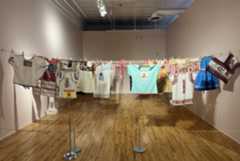 Embroidered blouses are strung up on a clothesline at the Museo de las América’s “Rosas y Revelaciones.”  (Ray Mark Rinaldi, Special to The Denver Post)