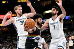Denver Nuggets guard Jamal Murray, center, handles the ball against Memphis Grizzlies center Jock Landale (31) and forward Santi Aldama (7) in the second half of an NBA basketball game Monday, Nov. 24, 2025, in Memphis, Tenn. (AP Photo/Brandon Dill)