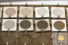 Figure 122: BepiColombo material samples after testing: Sample degradation after BepiColombo lifetime testing for ceramic reflective-surface thermal control materials. Only the central circle of each sample is exposed during testing, the border of each square revealing the original hue. Testing took place at 450ºC with UV radiation equivalent 10 times the sun for 25,000 hours under high vacuum conditions. The smaller the difference between the center and the edge, the more successful the test (image credit: ESA)