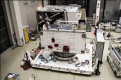 Figure 140: The spacecraft's 3.7m wide radiator side faces the viewer; this will be mounted with highly reflective fins to minimize absorption of heat radiated from Mercury, and to allow radiation towards deep space. The three oval shapes indicate startrackers, which will be used for navigation. The rectangular panel at the bottom close to center is the PHEBUS science instrument, an ultraviolet spectrometer. Small thruster units are also visible in each corner. The magnetometer and medium gain antenna booms are folded on the top; the high gain antenna is partially seen to the left (image credit: ESA–C.Carreau)