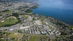 Vue aérienne du campus de l'EPFL ainsi que du lac Leman et de la chaine de montagne des Alpes en arrière plan.