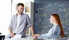 junger Mann und junge Frau unterhalten sich im Klassenzimmer