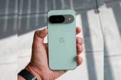 A hand holding a light green Google Pixel phone, resized to a 16:9 aspect ratio.