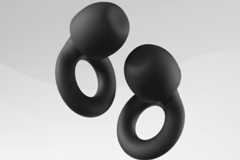 Two black, abstract, earring-like shapes with a matte finish, set against a professional light gray background with subtle wave patterns.