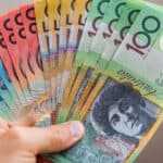 Person holding Australian dollar notes, symbolising dividends.