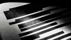 A black and white photo of a redacted document, with black blocks covering the lines of text